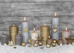 Świece w świątecznej dekoracji z bombkami i gwiazdkami