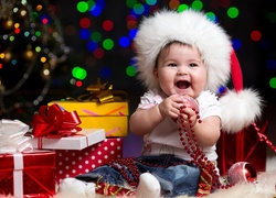Szczęśliwe dziecko wśród gwiazdkowych prezentów i bombek