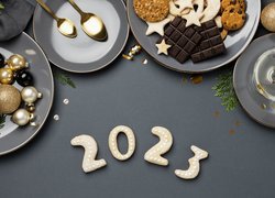 Talerze z ciasteczkami i bombkami nad datą 2023