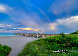 Tęcza nad morzem i molo na plaży w Juno Beach na Florydzie