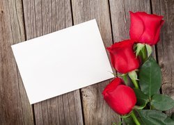 Trzy róże obok kartki papieru