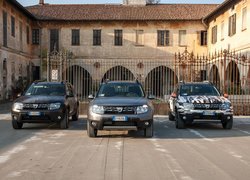 Trzy samochody marki Dacia Duster zaparkowane przed bramą