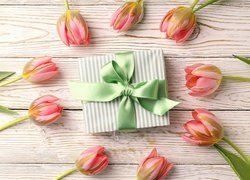 Tulipany dookoła prezentu na deskach