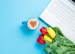 Tulipany i filiżanka kawy obok laptopa