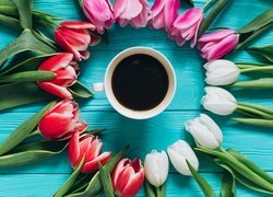 Tulipany ułożone wokół filiżanki z kawą