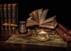 Tygielek i filiżanka kawy obok książek
