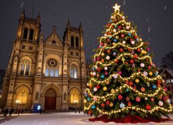 Udekorowana choinka i zapalone latarnie przed kościołem zimową porą