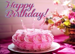Urodzinowy tort z życzeniami obok bukietu kwiatów