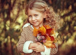 Uśmiechnięta dziewczynka z bukietem liści