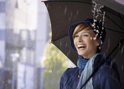 Uśmiechnięta kobieta pod parasolem
