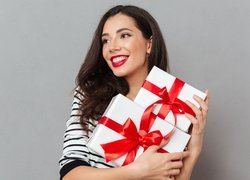 Uśmiechnięta kobieta z prezentami w rękach