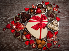 Walentynkowy prezent otoczony czekoladkami i serduszkami