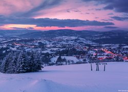 Widok na góry i oświetlone miasto w zimowej scenerii