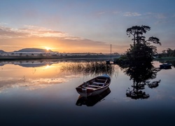 Widok na łódki i jezioro w świetle zachodzącego słońca