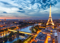 Widok na oświetloną wieżę Eiffla i Paryż o zmierzchu