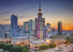 Widok na oświetlony Pałac Kultury i wieżowce w Warszawie