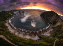 Widok z góry na Playa del Silencio w Cudillero i małą zatokę o zachodzie słońca