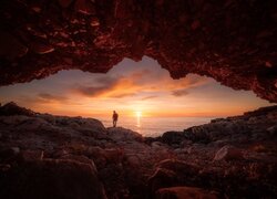 Widok z jaskini na człowieka spoglądającego na morze