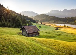 Widok z łąki na drewnianą szopę i jezioro Geroldsee