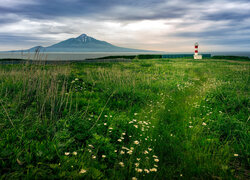 Widok z łąki na latarnie morską i wulkan na japońskiej wyspie Rishiri