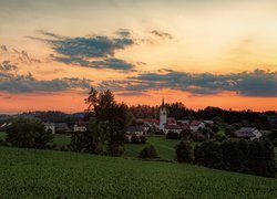 Widok z pola na miasteczko i kościół o zachodzie słońca