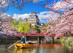 Widok z rzeki na Zamek Białej Czapli w Himeji pośród kwitnących wiśni w Japonii