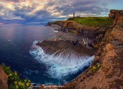 Widok ze skał na morze i latarnię morską Faro Cabo Mayor