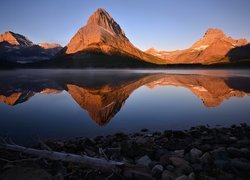 Widok znad jeziora Swiftcurrent Lake na szczyt Grinnell Point