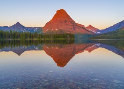 Widok znad jeziora Two Medicine Lake na drzewa i górę Sinopah