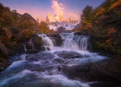 Widok znad rzeki na rozświetlone Andy i szczyt Fitz Roy