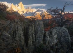 Widok zza skał na rozświetloną górę Fitz Roy