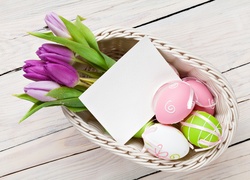 Wielkanocna dekoracja z pisankami i tulipanami w koszyczku