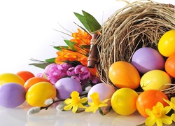 Wielkanocna kompozycja - kolorowe kwiaty i pisanki wypadające z gniazda