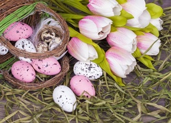 Wielkanocna kompozycja z pisanek w koszyku i tulipanów na sianku