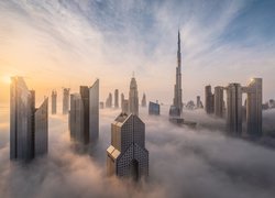 Wieżowce Dubaju w gęstej mgle o wschodzie słońca