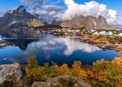 Norwegia, Lofoty, Wyspa Moskenesoya, Wioska Reine, Morze Norweskie Skały, Domy, Góry, Krzewy, Jesień, Chmury