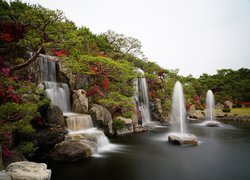 Wodospady pośród azalii i fontanny w ogrodzie