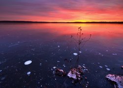 Wschód słońca nad pokrytym lodem jeziorem