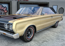 Zabytkowy samochód marki Plymouth GTX w złotym kolorze z 1967 roku
