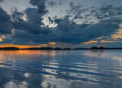 Zachmurzone niebo nad jeziorem wieczorową porą