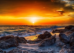 Zachód słońca nad kamienistą plażą