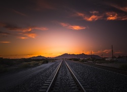 Zachodzące słońce nad torami kolejowymi