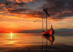 Żaglówka na morzu w blasku zachodzącego słońca