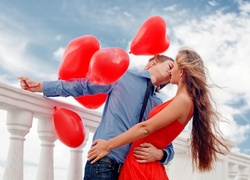 Zakochani z balonami na moście w walentynkowym pocałunku