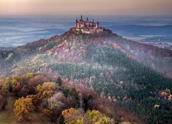 Zamek Hohenzollern na górze pośród jesiennych lasów