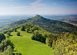 Zamek Hohenzollern na zalesionej górze w Niemczech