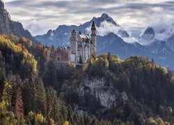 Zamek Neuschwanstein na skałach i góry we mgle