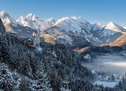 Zamek Neuschwanstein na tle ośnieżonych Alp