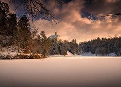 Zamek Trakoscan w Chorwacji nad zasypanym śniegiem jeziorem