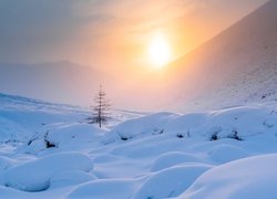 Zamglone słońce nad zimowymi górami